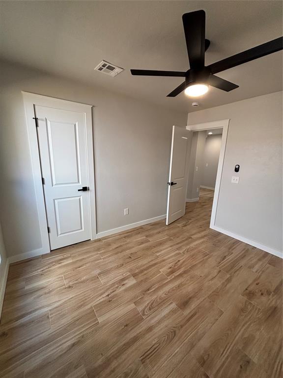 10501 Reiter Dr, Midwest City, OK 73130 - unfurnished bedroom with light wood-style floors, baseboards, and ceiling fan
