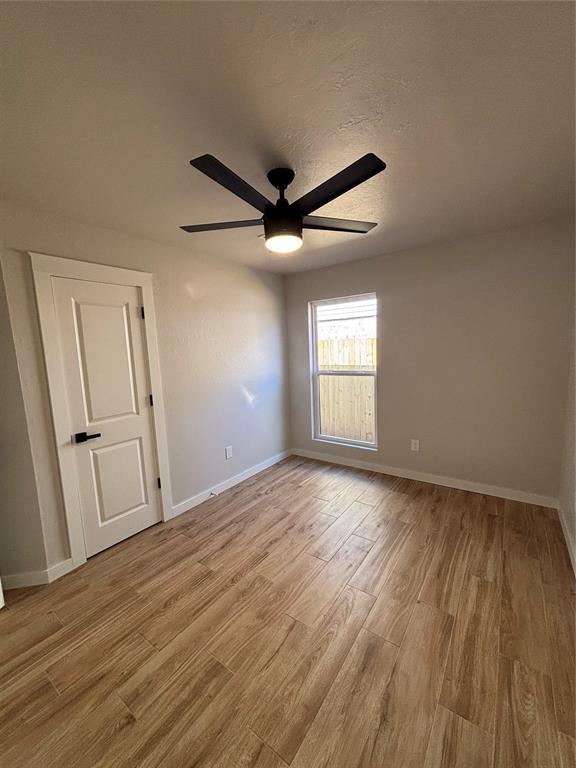 10501 Reiter Dr, Midwest City, OK 73130 - spare room featuring light wood finished floors, ceiling fan, and baseboards