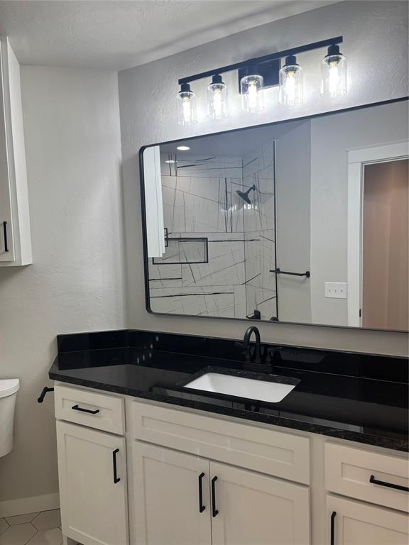 10501 Reiter Dr, Midwest City, OK 73130 - full bath with toilet, vanity, tile patterned flooring, a shower, and baseboards