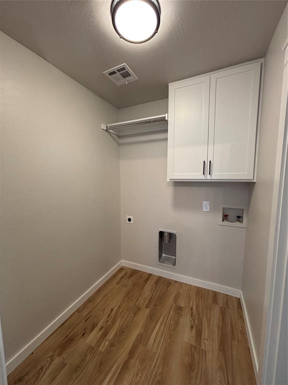 10501 Reiter Dr, Midwest City, OK 73130 - laundry room featuring hookup for a washing machine, cabinet space, baseboards, and wood finished floors