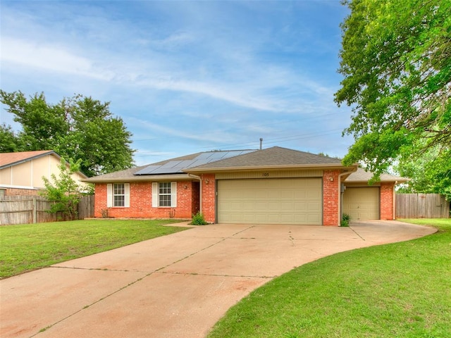105 Taos, Edmond, OK 73013 - ranch-style house featuring a garage, concrete driveway, solar panels, and brick siding