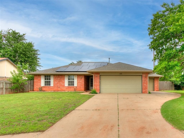 105 Taos, Edmond, OK 73013 - ranch-style house with a garage, driveway, solar panels, and brick siding