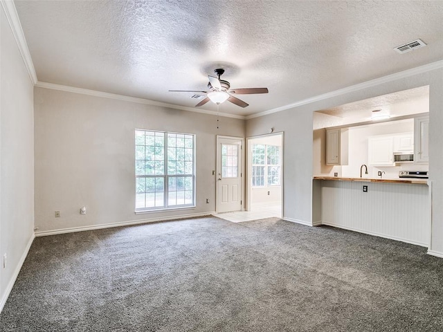 105 Taos, Edmond, OK 73013 - unfurnished living room with ceiling fan, a textured ceiling, dark colored carpet, and ornamental molding
