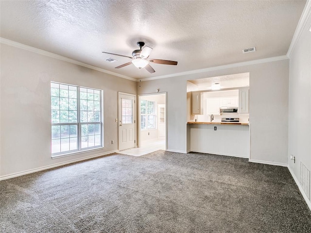 105 Taos, Edmond, OK 73013 - unfurnished living room with a textured ceiling, ceiling fan, carpet flooring, and crown molding