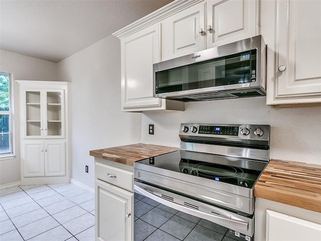 105 Taos, Edmond, OK 73013 - kitchen with stainless steel appliances, butcher block counters, light tile patterned floors, and white cabinets