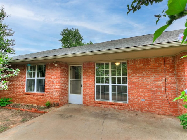 105 Taos, Edmond, OK 73013 - property entrance with a patio area and brick siding