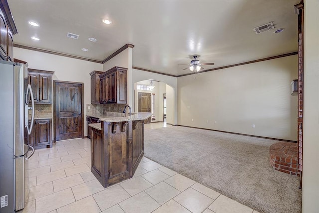 811 W Abi Rd, Washington, OK 73093 - kitchen with freestanding refrigerator, arched walkways, light carpet, ceiling fan, and a peninsula