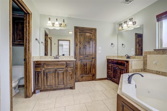 811 W Abi Rd, Washington, OK 73093 - bathroom featuring a tub with jets, two vanities, tile patterned floors, toilet, and baseboards