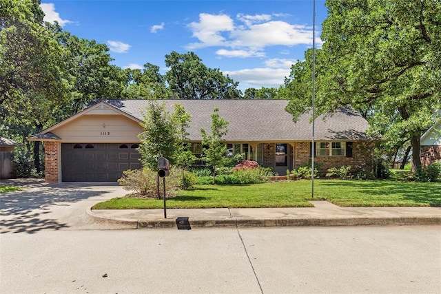 1112 E 11th St, Edmond, OK 73034 - ranch-style home with concrete driveway, a garage, a front lawn, and brick siding