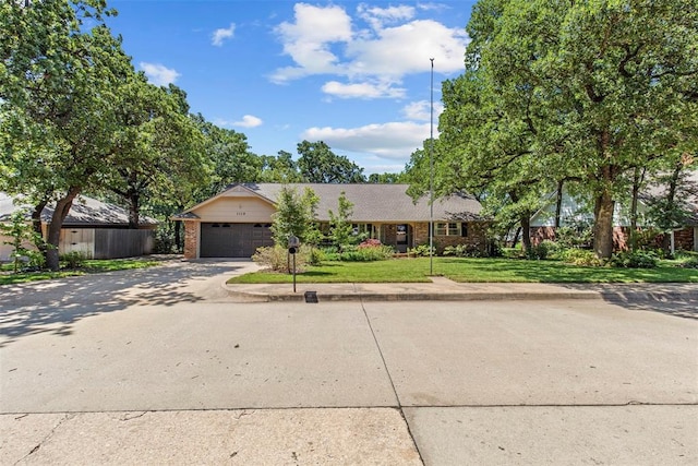 1112 E 11th St, Edmond, OK 73034 - single story home with brick siding, a garage, concrete driveway, and a front yard