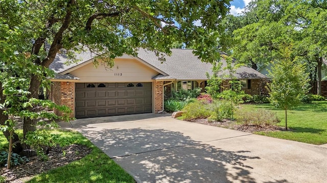 1112 E 11th St, Edmond, OK 73034 - single story home with driveway, a garage, brick siding, and a front yard