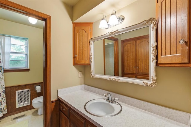 1112 E 11th St, Edmond, OK 73034 - bathroom featuring toilet, vanity, heating unit, and wainscoting