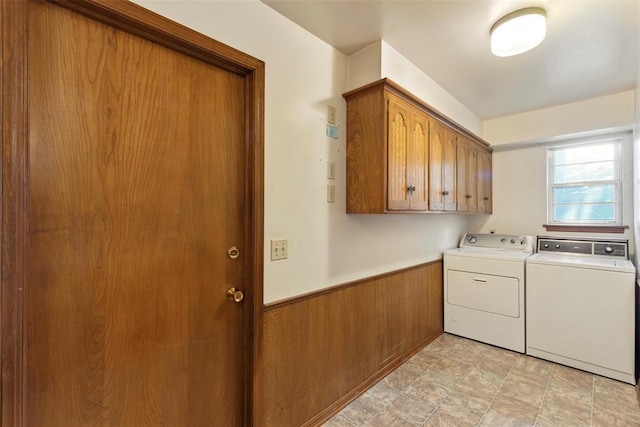 1112 E 11th St, Edmond, OK 73034 - laundry room featuring washing machine and dryer, cabinet space, wainscoting, wooden walls, and stone finish floors