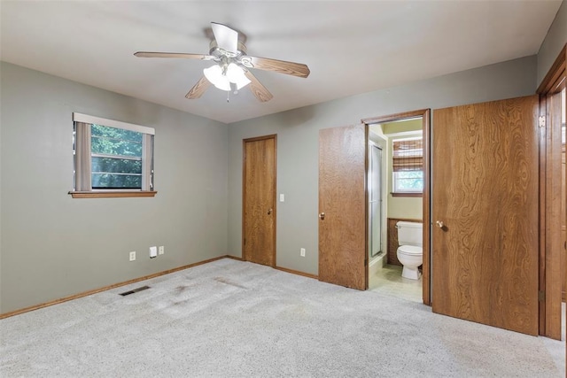 1112 E 11th St, Edmond, OK 73034 - unfurnished bedroom with multiple windows, carpet floors, baseboards, and connected bathroom