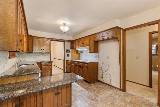 1112 E 11th St, Edmond, OK 73034 - kitchen featuring a sink, white appliances, brown cabinetry, and under cabinet range hood