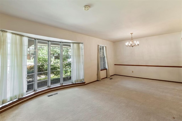 1112 E 11th St, Edmond, OK 73034 - carpeted spare room with a chandelier, a smoke detector, and baseboards