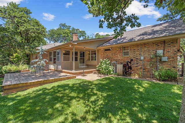 1112 E 11th St, Edmond, OK 73034 - back of house featuring a chimney, a deck, a yard, and brick siding