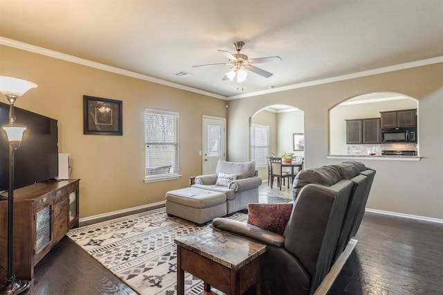 5008 Caleb St, Oklahoma City, OK 73179 - living room with arched walkways, a ceiling fan, dark wood-type flooring, baseboards, and ornamental molding