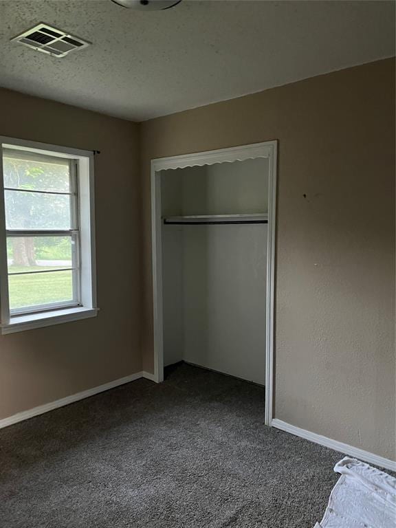 1209 Jefferson St, Seminole, OK 74868 - unfurnished bedroom featuring dark colored carpet, baseboards, and a closet