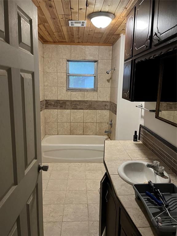 1209 Jefferson St, Seminole, OK 74868 - bathroom with vanity, wood ceiling, bathing tub / shower combination, and tile patterned floors