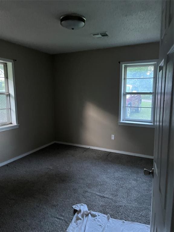 1209 Jefferson St, Seminole, OK 74868 - empty room with dark carpet and baseboards
