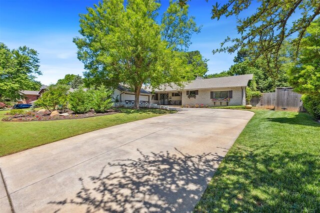 2241 NW 56th St, Oklahoma City, OK 73112 - ranch-style home featuring concrete driveway, a garage, and brick siding