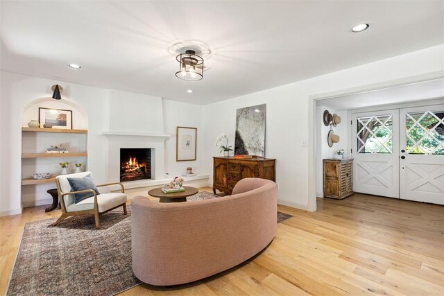 2241 NW 56th St, Oklahoma City, OK 73112 - living room with light wood-type flooring, a lit fireplace, french doors, recessed lighting, and baseboards