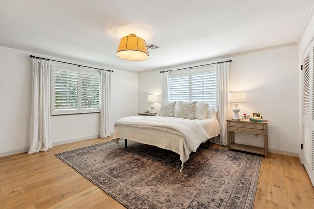 2241 NW 56th St, Oklahoma City, OK 73112 - bedroom with light wood-type flooring, crown molding, and baseboards