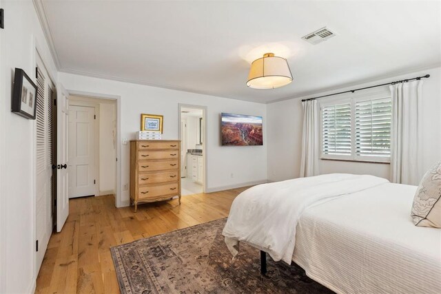 2241 NW 56th St, Oklahoma City, OK 73112 - bedroom featuring light wood-style floors, baseboards, ensuite bath, and a closet