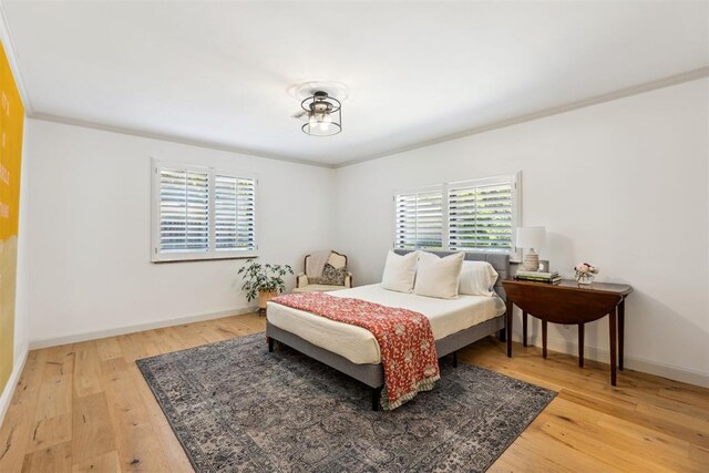 2241 NW 56th St, Oklahoma City, OK 73112 - bedroom featuring multiple windows, ornamental molding, light wood-type flooring, and baseboards