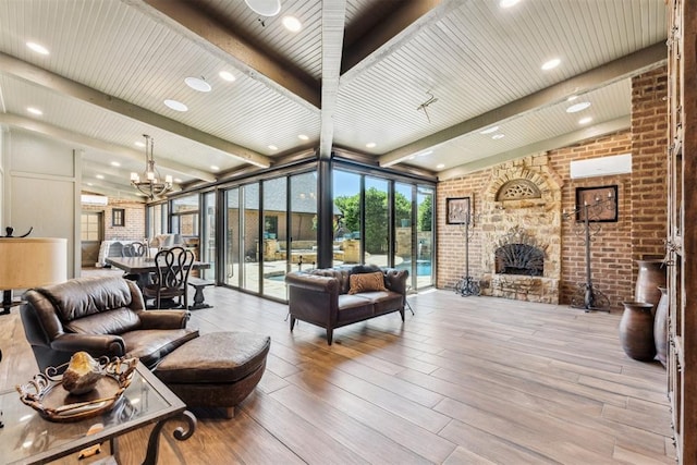 1324 NW 157th St, Edmond, OK 73013 - living room featuring brick wall, a chandelier, a large fireplace, wood-type flooring, and recessed lighting