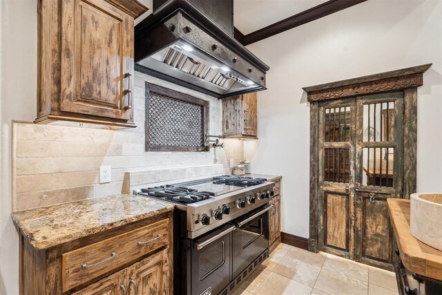 1324 NW 157th St, Edmond, OK 73013 - kitchen featuring range with two ovens, custom exhaust hood, backsplash, light stone countertops, and baseboards