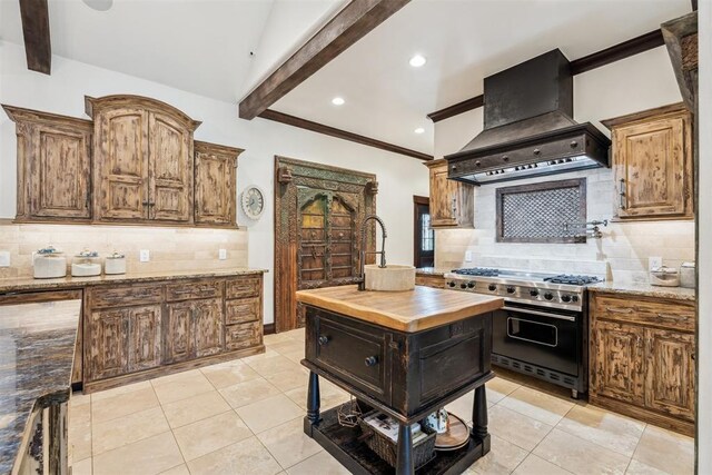 1324 NW 157th St, Edmond, OK 73013 - kitchen with double oven range, custom exhaust hood, butcher block countertops, beamed ceiling, and decorative backsplash