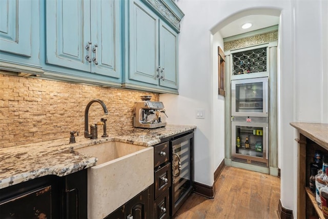 1324 NW 157th St, Edmond, OK 73013 - kitchen with wine cooler, a sink, arched walkways, and blue cabinets
