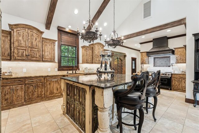 1324 NW 157th St, Edmond, OK 73013 - kitchen with premium range hood, high end stainless steel range oven, backsplash, a center island, and dark stone counters