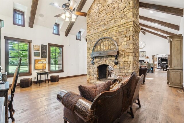 1324 NW 157th St, Edmond, OK 73013 - living area with high vaulted ceiling, beam ceiling, a ceiling fan, a fireplace, and wood finished floors