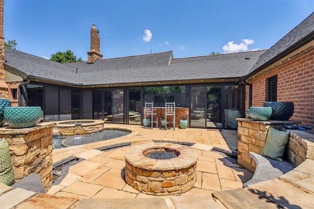1324 NW 157th St, Edmond, OK 73013 - view of patio / terrace featuring an outdoor fire pit, a sunroom, and an in-ground hot tub