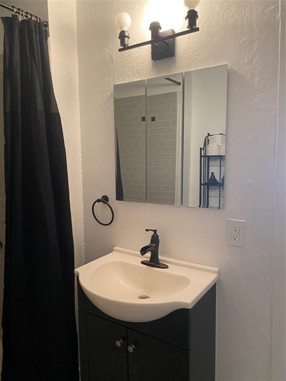 640 SE 20th St, Oklahoma City, OK 73129 - bathroom featuring vanity, a textured wall, and a shower with shower curtain