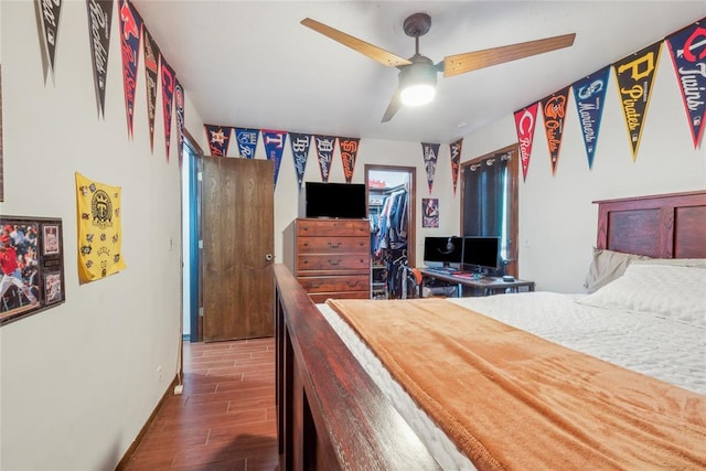 13220 Shady Tree Pl, Edmond, OK 73013 - bedroom featuring wood finished floors, a walk in closet, ceiling fan, a closet, and baseboards