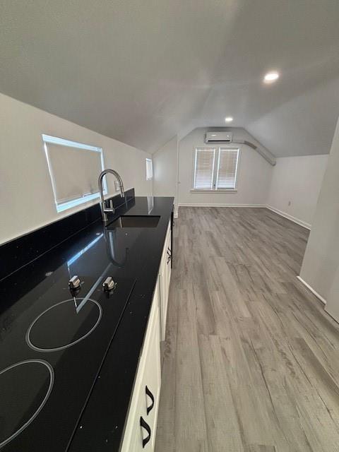306 E Hughbert St, Norman, OK 73069 - bonus room featuring a sink, a wall mounted AC, light wood-style flooring, lofted ceiling, and baseboards