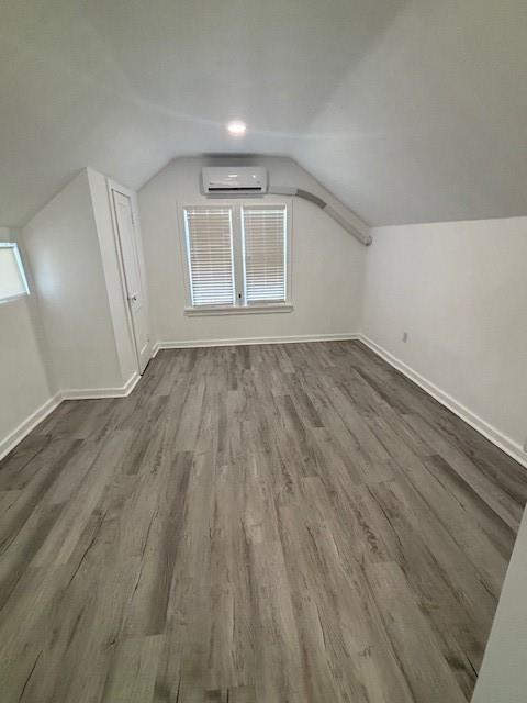 306 E Hughbert St, Norman, OK 73069 - bonus room with a wall unit AC, dark wood-style flooring, baseboards, and vaulted ceiling