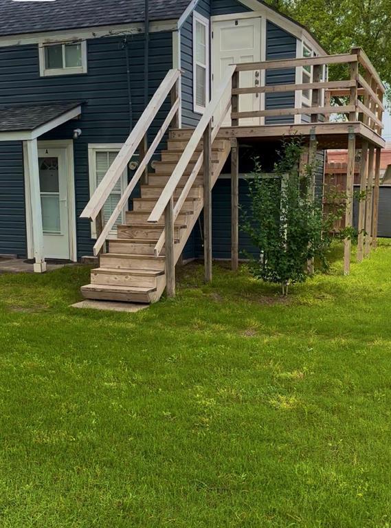 306 E Hughbert St, Norman, OK 73069 - rear view of house with roof with shingles, a wooden deck, a yard, and stairway