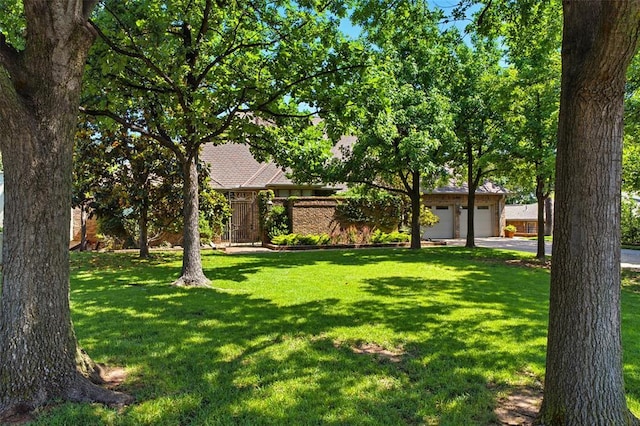 1409 Glenbrook Ter, Nichols Hills, OK 73116 - view of grassy yard with driveway and an attached garage