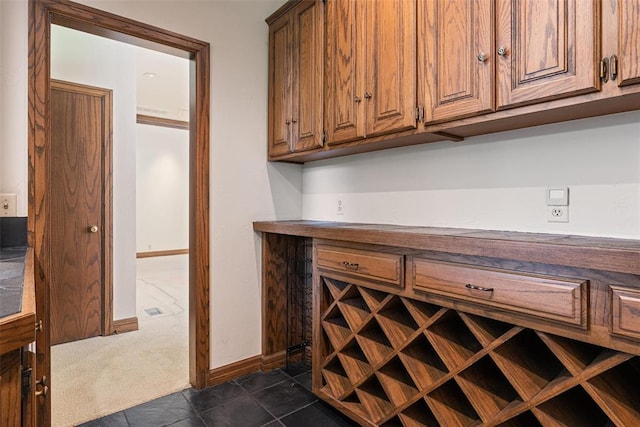 1409 Glenbrook Ter, Nichols Hills, OK 73116 - bar with baseboards, dark tile patterned flooring, and dark colored carpet
