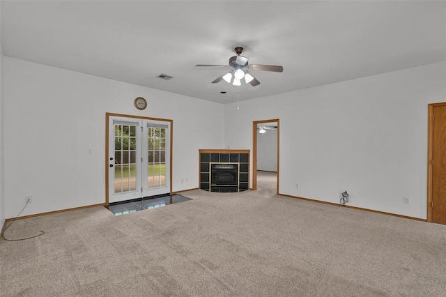 1101 Wendy Ln, Altus, OK 73521 - unfurnished living room with a ceiling fan, carpet flooring, baseboards, and a tiled fireplace