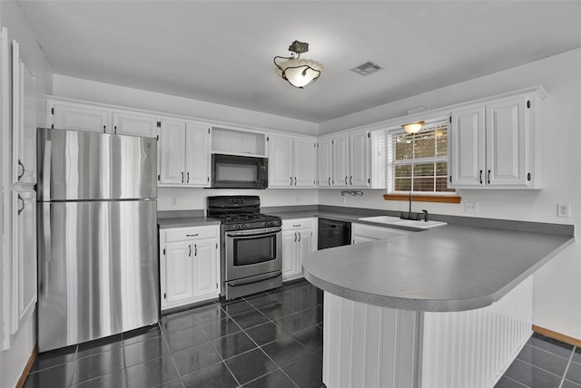 1101 Wendy Ln, Altus, OK 73521 - kitchen with black appliances, a sink, a peninsula, dark tile patterned floors, and white cabinets