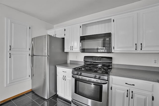 1101 Wendy Ln, Altus, OK 73521 - kitchen featuring stainless steel appliances, white cabinets, dark tile patterned floors, and dark countertops