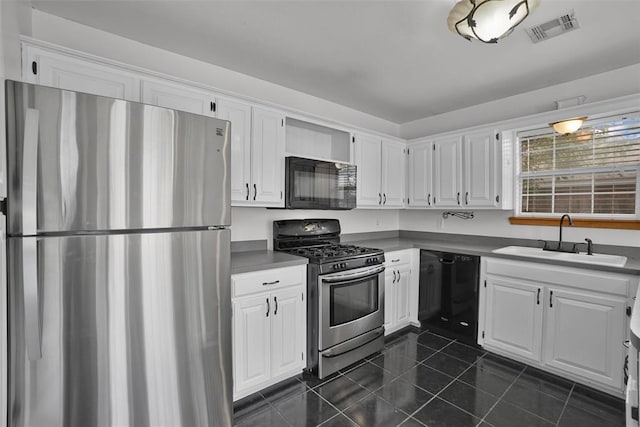 1101 Wendy Ln, Altus, OK 73521 - kitchen with black appliances, a sink, white cabinetry, and dark tile patterned flooring