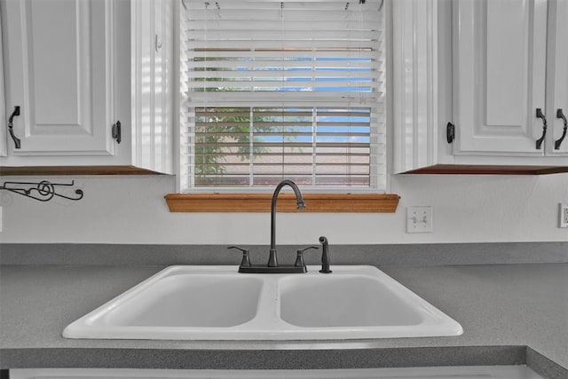 1101 Wendy Ln, Altus, OK 73521 - kitchen view of a sink, dark countertops, and white cabinetry