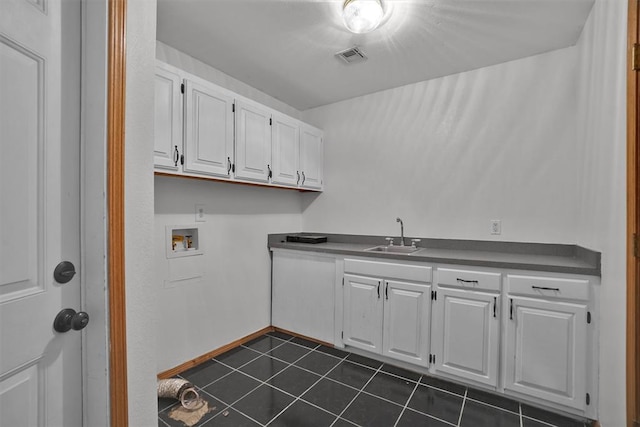 1101 Wendy Ln, Altus, OK 73521 - washroom featuring cabinet space, hookup for a washing machine, dark tile patterned floors, and baseboards